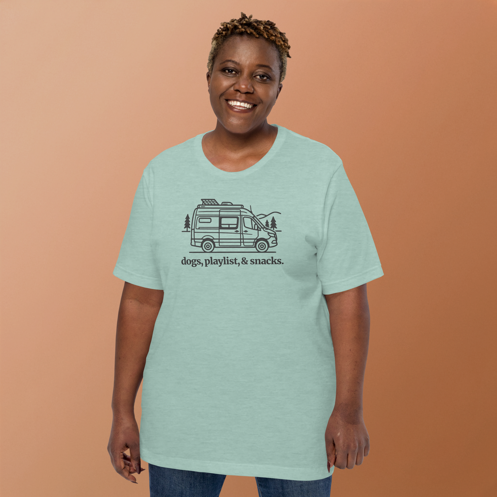 Person wearing Rv/camper van silhouette  with typography  'dogs, playlist, snacks underneath. Printed on Bella + Canvas heather prism dusty blue tshirt. 