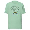 The Queer Pickles above 2 crossed paddles with pickleball,  with 1965 club style. Printed on unisex Bella + Canvas heather prism mint tshirt. Center Chest black in and rainbow handles.