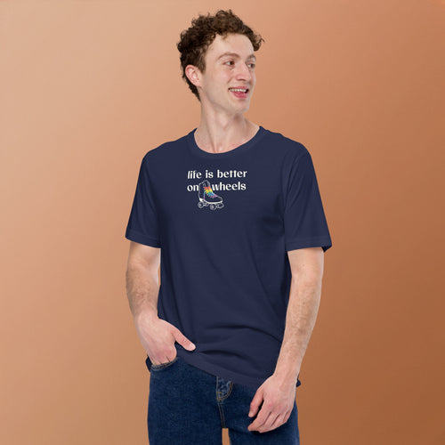 Model wearing Minimalist off white typography life is better on wheels with a small silhouette of a roller skate with LGBTQ+ laces. On navy unisex Bella + Canvas tee. High center chest