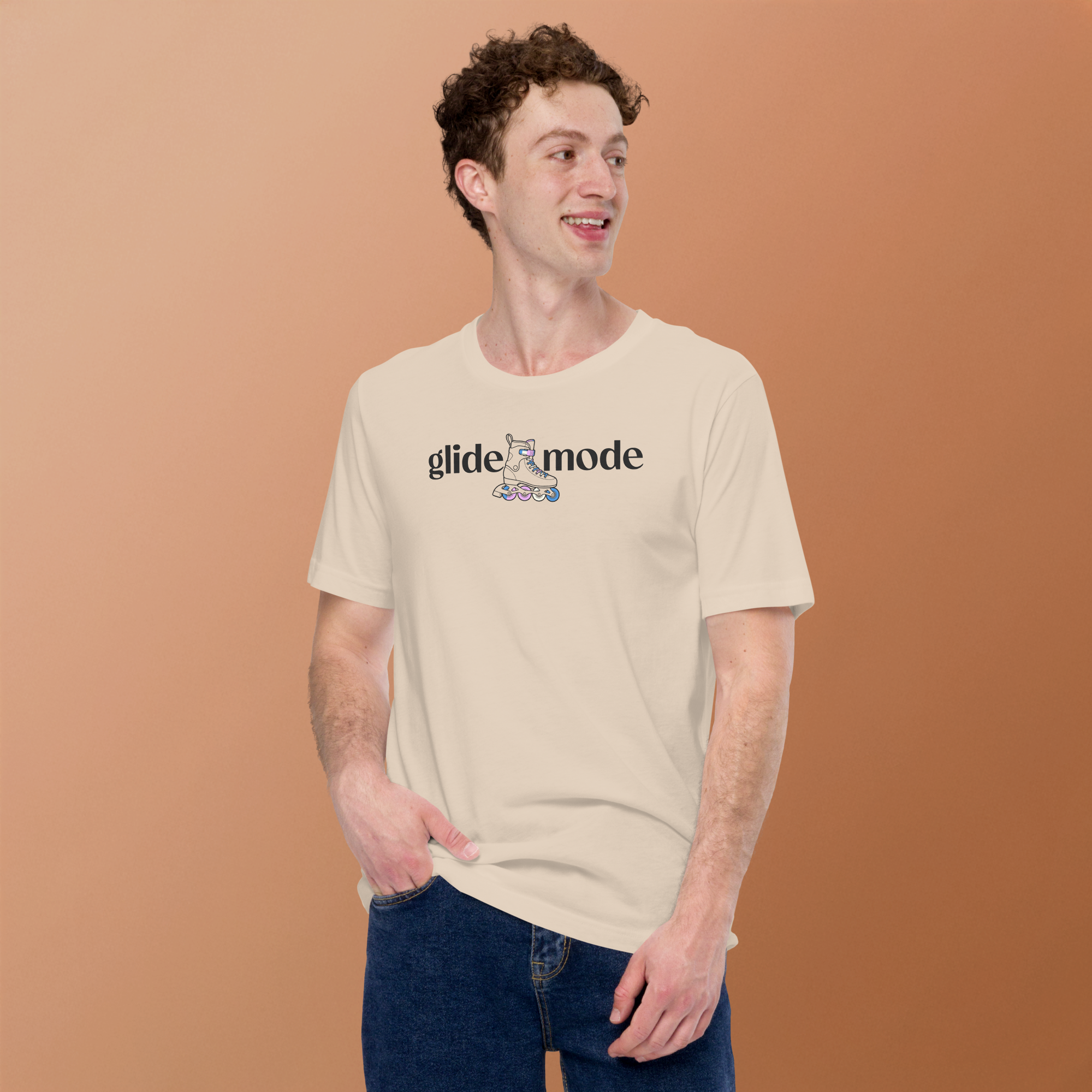 Model wearing beige Coded LGBTQ+ glide mode typography shirt with minimal inline skate icon with white, pink, and blue accents. Unisex Bella + Canvas cotton. High center chest off-black ink.