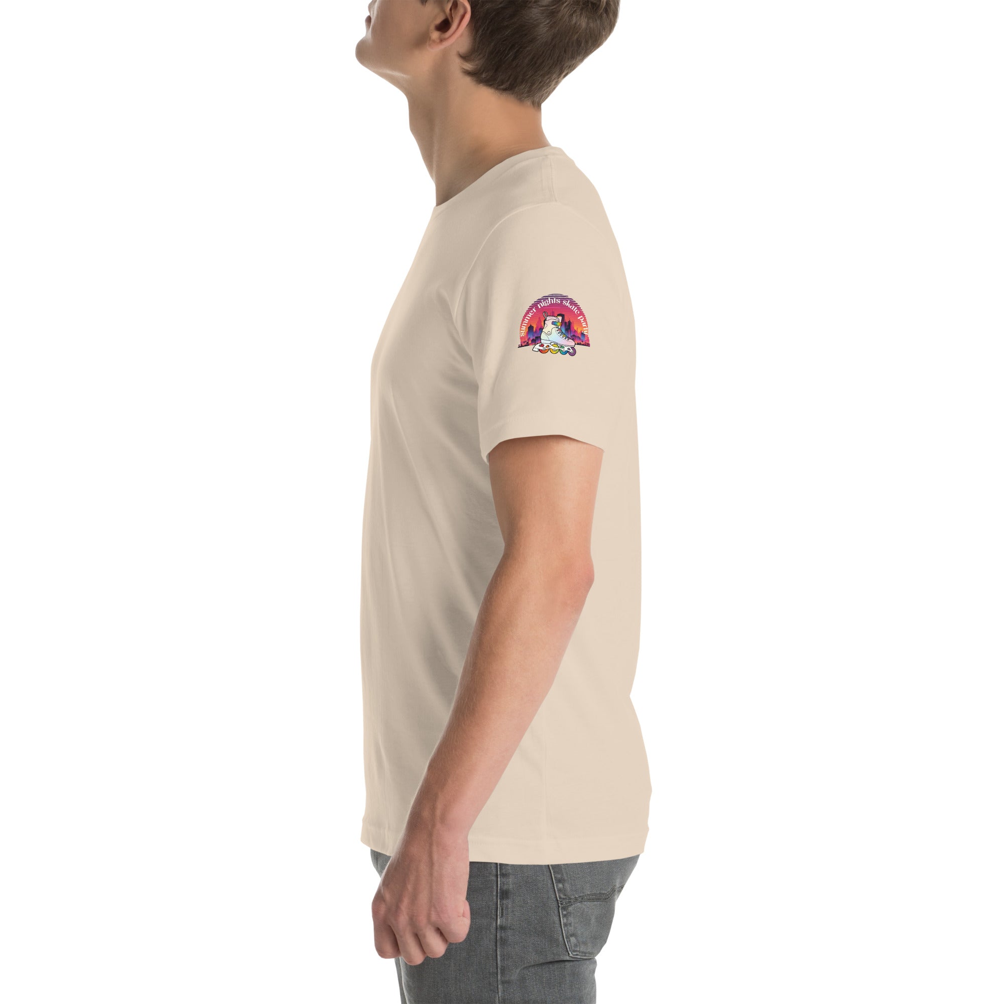 Side view of model wearing colorful skyline at sunset with inline skate in LGBTQ+ rainbow colors. Left sleeve print on unisex beige Bella + Canvas cotton.  Paired with jeans.