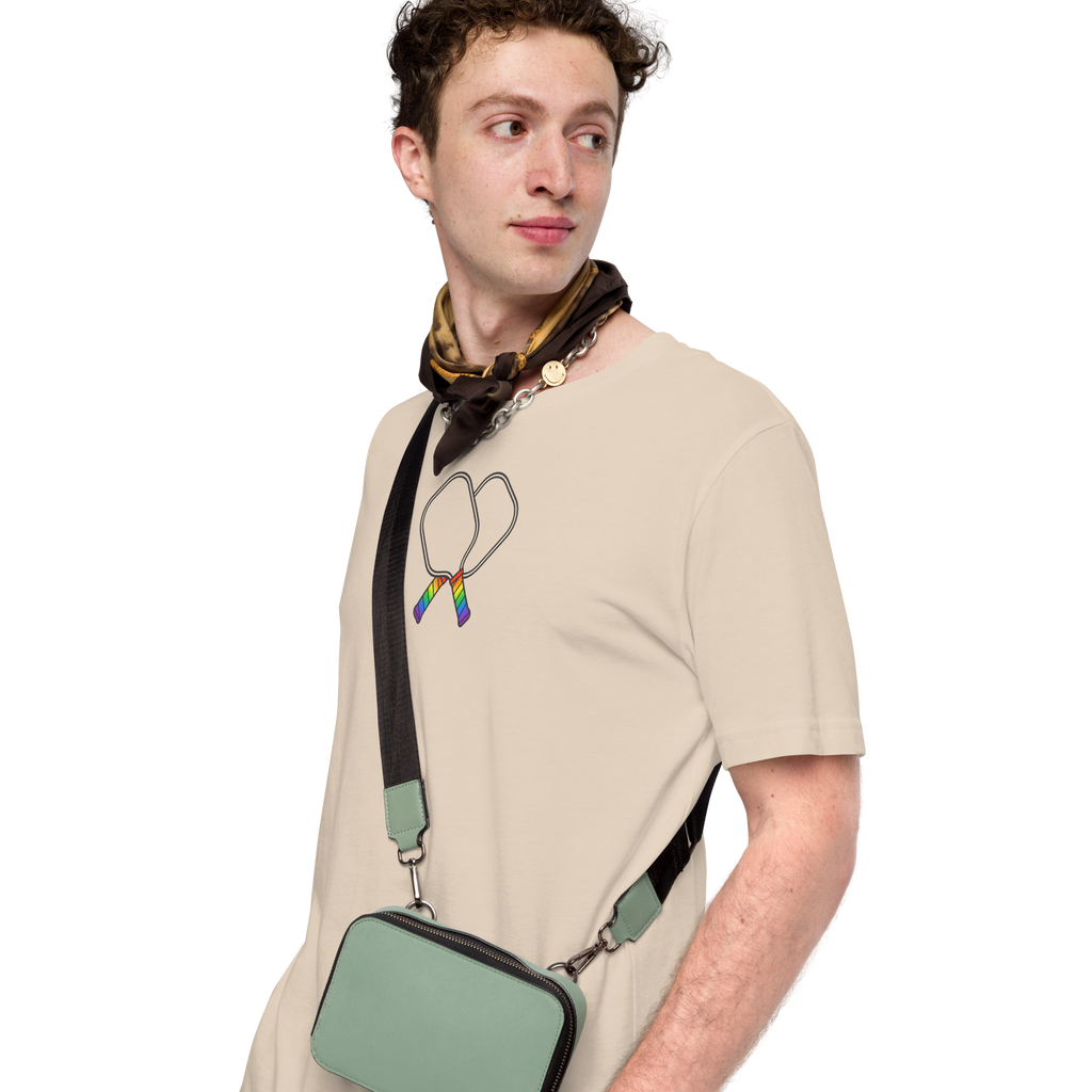 person wearing Minimalist Crossed pickleball paddles  with rainbow handles on unisex cotton soft cream beige Bella + Canvas tshirt. High center chest