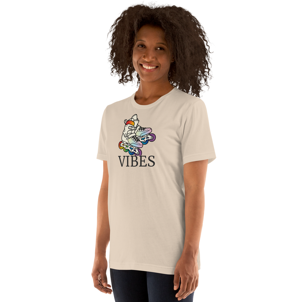 Model wearing 2 inline skates in LGBTQ+ rainbow colors above VIBES text. Beige Bella + Canvas Cotton.  Paired with jeggings.