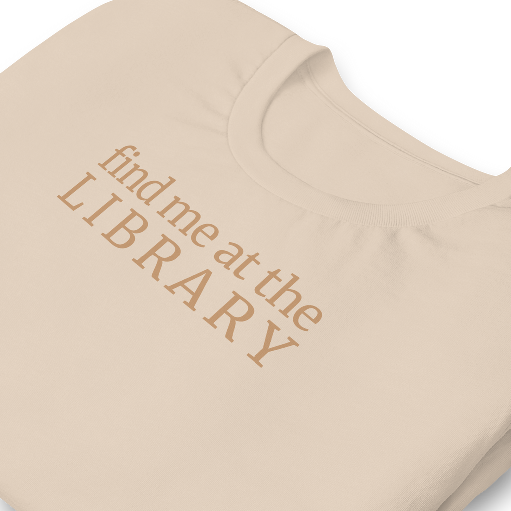 "Find Me at the Library" minimalist typography tee. On Bella + Canvas unisex cotton. Terra cotta ink on soft cream beige shirt. Close up print and collar