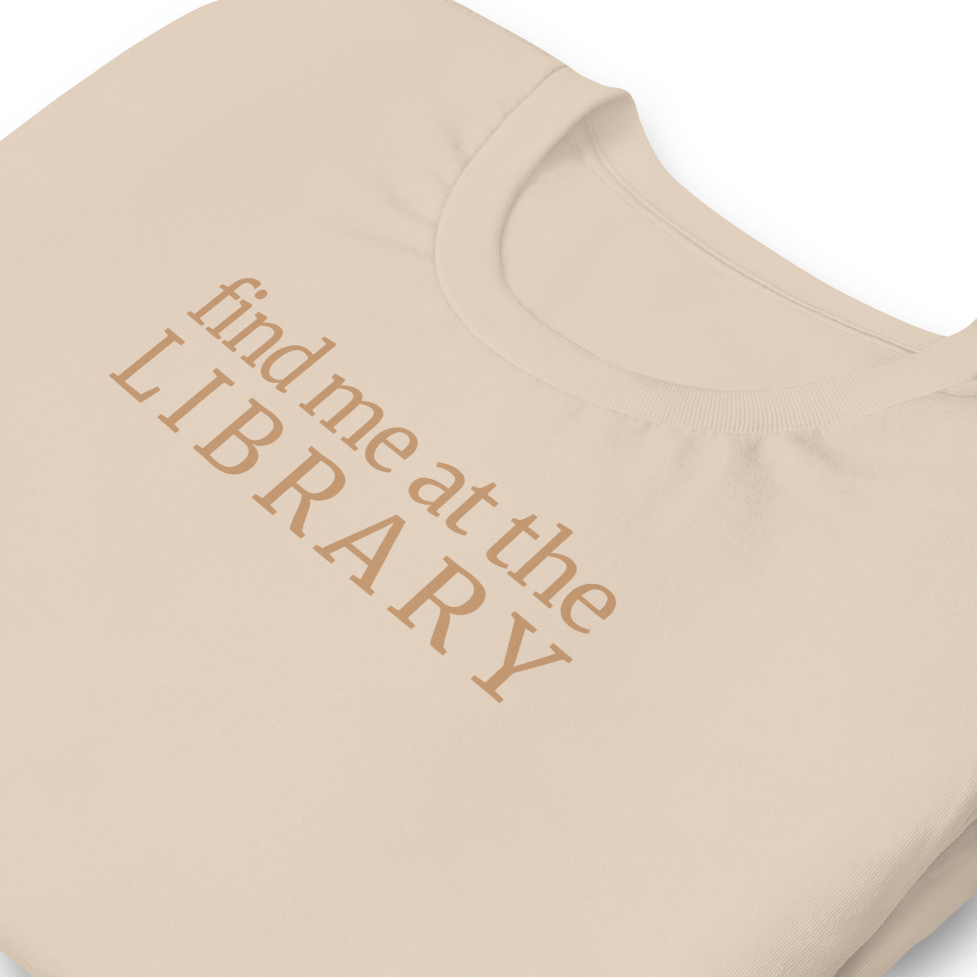"Find Me at the Library" minimalist typography tee. On Bella + Canvas unisex cotton. Terra cotta ink on soft cream beige shirt. Close up print and collar